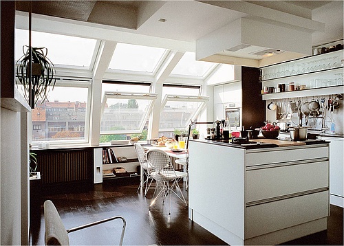 Ein Dachgeschossraum mit dunklem Fußboden kann sehr edel aussehen, braucht jedoch viel Licht, um auch eine Küche richtig in Szene setzen zu können – idealerweise durch große Fensterflächen. (Foto: Velux Deutschland GmbH)