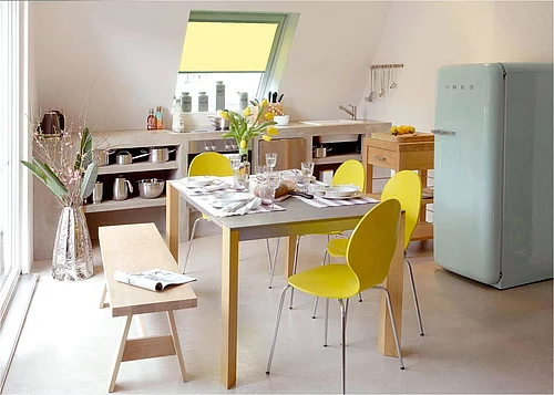 Die Bewohner dieser Dachgeschosswohnung sorgen mit farblichen Akzenten bei Mobiliar, Dekoration und Sonnenschutz-Produkten selbst bei Schmuddelwetter für sonnige Stimmung in der Küche. (Foto: Velux Deutschland GmbH)