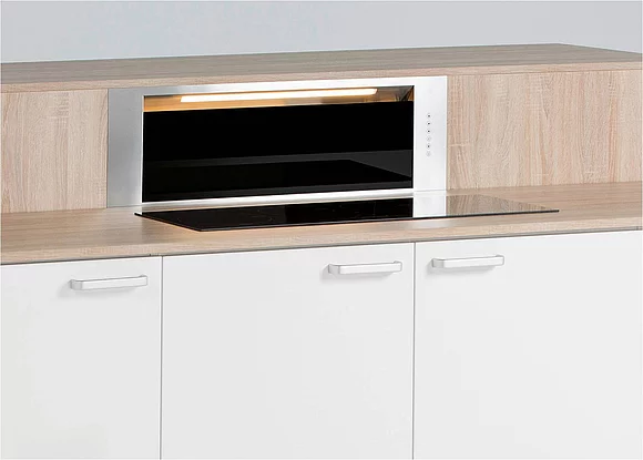 Hier ist der Dunstabzug in eine höhenverstellbare Kochinsel, ein so genanntes elektrisches Hubmodul integriert und lässt sich dadurch immer exakt auf die jeweilige Höhe des Kochgeschirrs ausrichten. (Foto: Arbeitsgemeinschaft Die Moderne Küche e.V. (AMK))