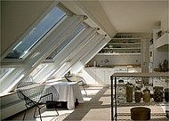 Gleich acht Dachfenster sorgen für viel Licht in dieser sonnigen Dachgeschoss-Küche. Falls es einmal zu heiß wird, leisten Hitzeschutz-Markisen außen vor dem Fenster Abhilfe. (Foto: Velux Deutschland GmbH)